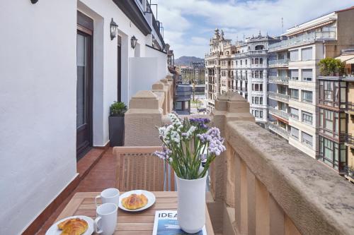 Un balcón con una mesa con flores. en Mirakruz Terrace by FeelFree Rentals, en San Sebastián