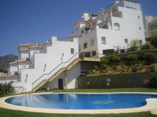 a building with a swimming pool in front of a building at Fantástico estudio en Urbanización Vela de Mar in Benalmádena