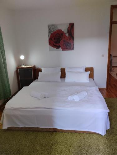ein weißes Bett mit zwei Handtüchern darüber in der Unterkunft Sejmen in Sarajevo
