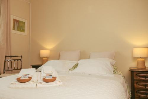 a bedroom with a bed with two towels and two lamps at AmendoeirasHouse-SustainableLiving in Abrantes