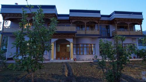 a large white house with a front door and trees at Hotel Bergo Residency - Leh in Leh