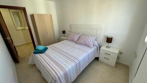 Un dormitorio pequeño con una cama y una mesita de noche. en APARTAMENTO el CARMEN, en Baeza