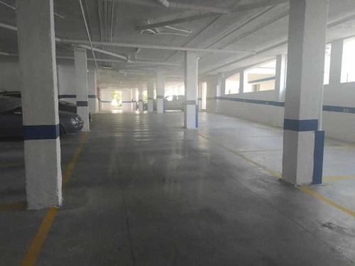 an empty parking garage with white and blue columns at Estudio en Nueva Torrequebrada in Benalmádena