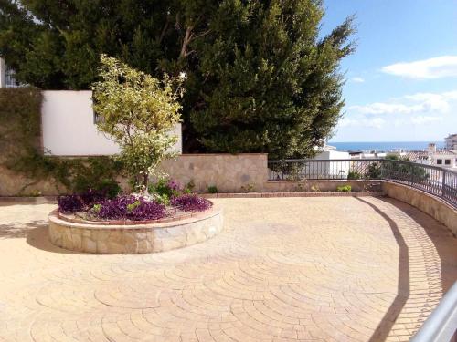 a brick walkway with a planter with a tree in it at Estudio en Nueva Torrequebrada in Benalmádena
