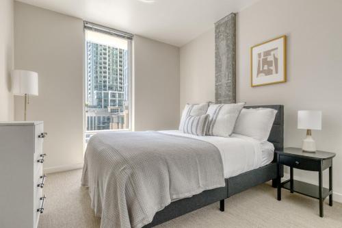 a white bedroom with a large bed and a window at Downtown Bellevue 2BR w Lounge Gyms nr shops SEA-122 in Bellevue