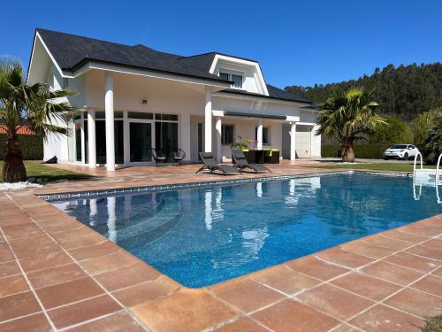 una piscina frente a una casa en Villa LA PERLA con piscina privada, en Parbayón