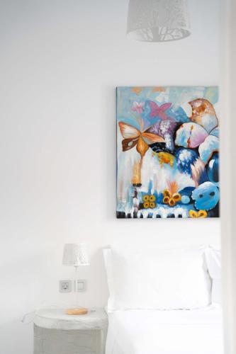 a bedroom with a painting on the wall next to a bed at Sunrise Villa Santorini in Vourvoulos