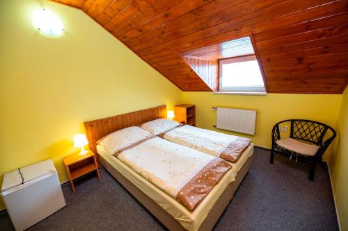 Un dormitorio con una cama grande y una ventana en Penzion Myslivna, en Lednice