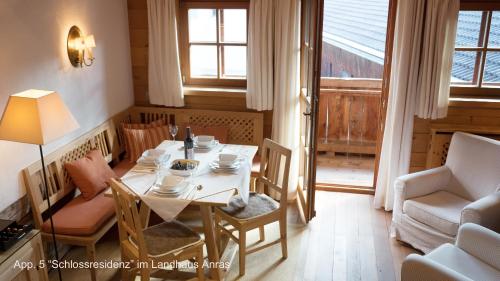 ein Esszimmer mit einem Tisch, Stühlen und einem Fenster in der Unterkunft Landhaus & Schloss Anras in Anras