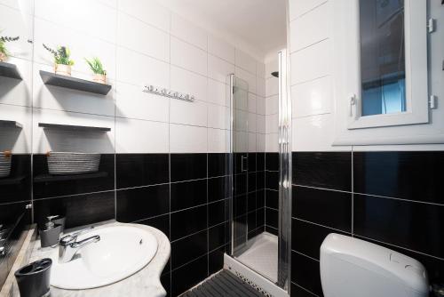 un bagno bianco e nero con servizi igienici e lavandino di Les Arcades - Appartement vue mer ad Argelès-sur-Mer