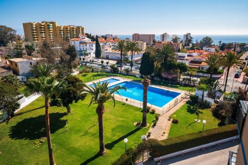 een luchtzicht op een park met een zwembad en palmbomen bij Coqueto apartamento con vistas in Torremolinos