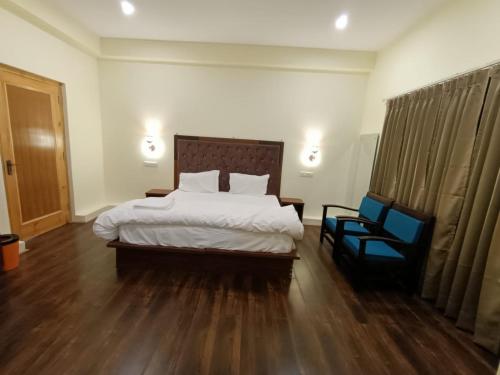 a hotel room with a bed and a chair at Hotel Bergo Residency - Leh in Leh