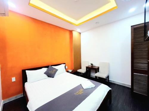 een slaapkamer met een groot bed met een oranje muur bij Nam Anh 2 Hotel in Ho Chi Minh-stad