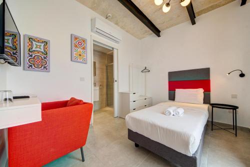 a bedroom with a bed and a red couch at Casa Domenico 8 in Valletta