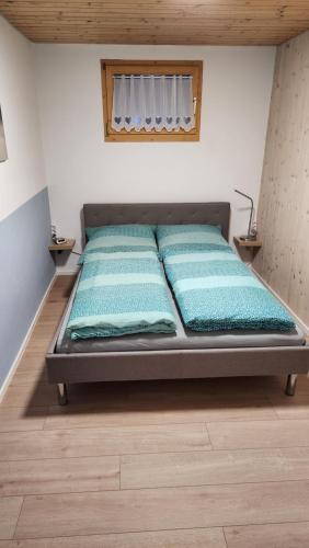 Bett in einem Zimmer mit zwei Kissen darauf in der Unterkunft Allgäunest in Leutkirch im Allgäu