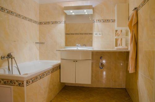 y baño con bañera y lavamanos. en Penzion Myslivna, en Lednice