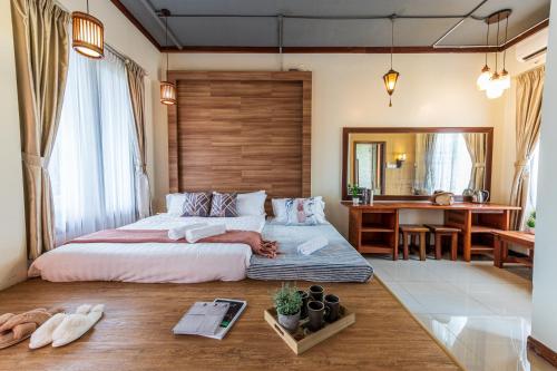 1 dormitorio con 1 cama grande y escritorio en Bentong Eco Wellness Resort 14Room 69Pax by Verano Homestay en Bentong