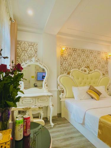 a bedroom with a bed and a mirror and a desk at Diamond Hotel Ha Noi in Hanoi