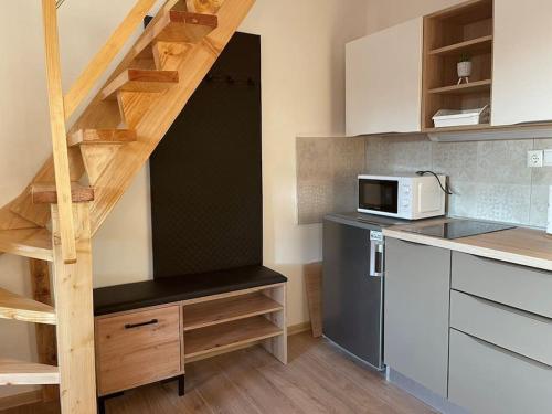 a small kitchen with a staircase and a microwave at Apartman 4YOU Central station - GARAGE - Self check in in Osijek