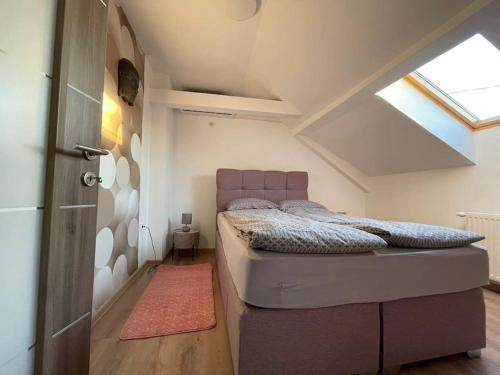 a bedroom with a bed in a attic at Apartman 4YOU Central station - GARAGE - Self check in in Osijek