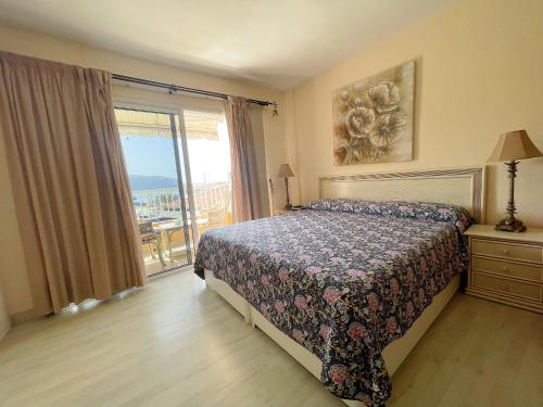 a bedroom with a bed and a window with a view at Edificio Arco in Los Cristianos