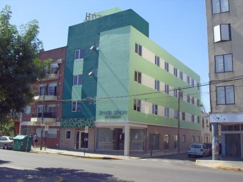 a green building on the corner of a street at Hotel Micro in Rosario