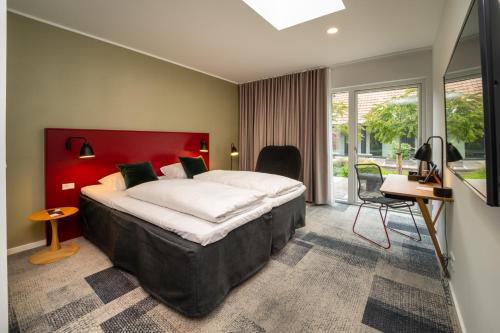 a bedroom with a large bed with a red headboard at Skanderborg Park in Skanderborg