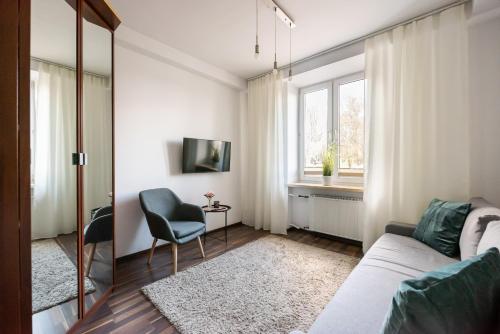 een woonkamer met een bank en een raam bij Dobra Old Town Apartment in Warschau