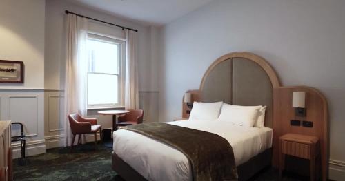 Habitación de hotel con cama y ventana en Portarlington Grand Hotel, en Portarlington