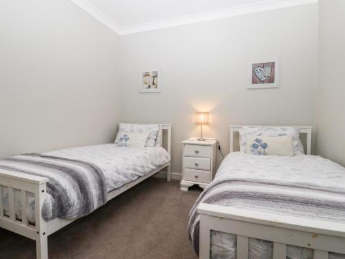 a bedroom with two beds and a lamp on a night stand at Sea Beach Cottage in Eastbourne