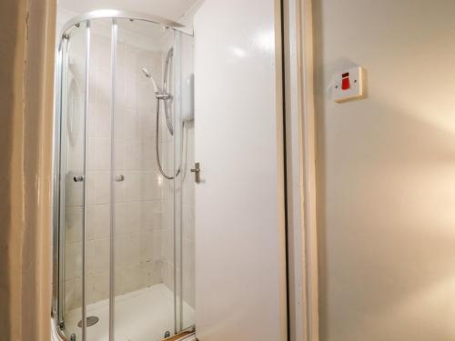 a shower with a glass door in a bathroom at Sea Beach Cottage in Eastbourne