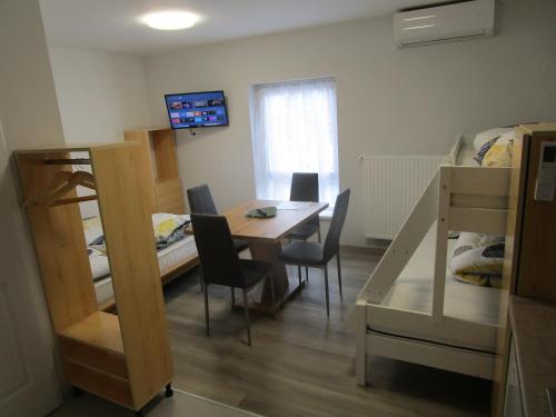 Zimmer mit einem Tisch, Stühlen und einem Bett in der Unterkunft Veroland Magánszálláshely in Hódmezővásárhely