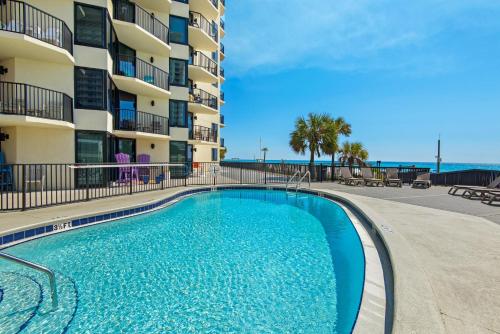a swimming pool in front of a apartment building at Sunbird 709W Beach Life in Panama City Beach