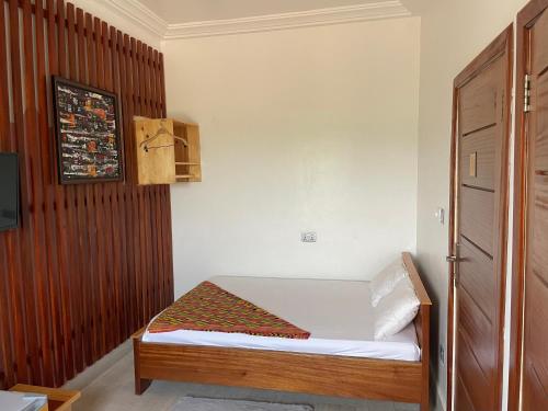 a small bedroom with a bed and a tv at Theo Good Life Hotel in Big Ada