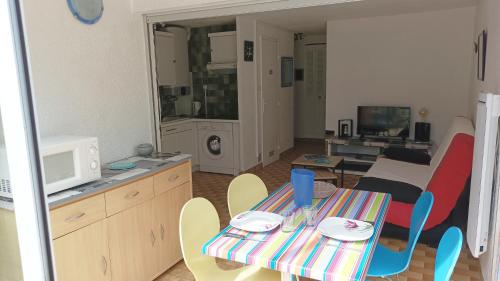 a small living room with a table and chairs at Lara 6 - Grand T2 Terrasse Loggia - WC indép - Parking - Quartier calme entre centre-port et île des Loisirs plage Richelieu in Cap d'Agde