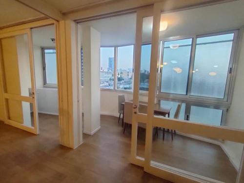 テルアビブにあるHavakouk Beach apartmentのテーブルと椅子、窓が備わる客室です。