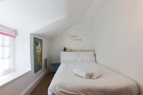 a bedroom with a bed with white sheets and a window at Welcome to Port Isaac - Padstow - Polzeath in Saint Teath
