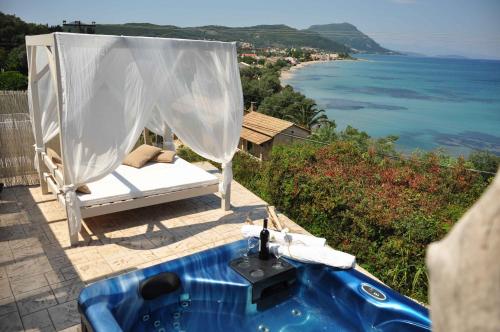 a bath tub on a patio with a view of the ocean at Palms and Spas Villas Retreat in Mesongi