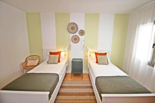 two beds in a room with green walls at MILÚ GOLF LUXURY HOUSE in Caleta De Fuste