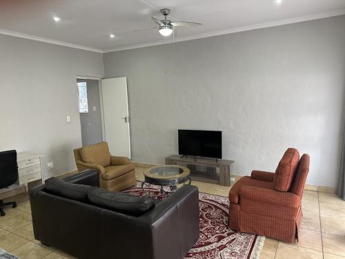 a living room with a couch and two chairs and a tv at Luxury and Comfort Hideaway 2 - Solar Powered in Pretoria