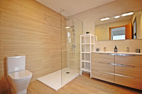 a bathroom with a shower and a toilet and a sink at MILÚ GOLF LUXURY HOUSE in Caleta De Fuste
