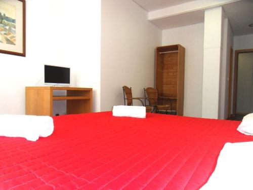 a bedroom with a red bed with a red blanket at Guest House Rooms in Bairro Alto in Lisbon