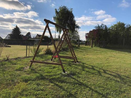 Bungalow Rudensicht في Freest: وضع أرجوحة خشبية في حقل من العشب