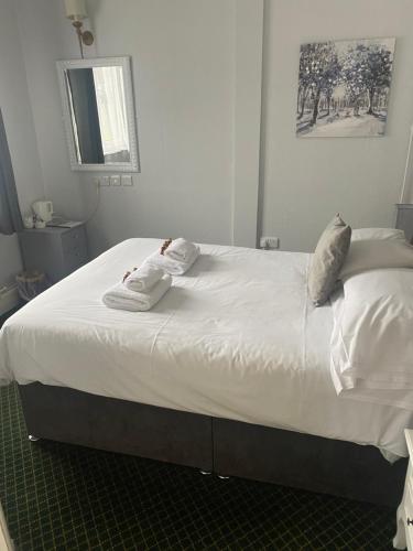 a large bed with white sheets and pillows on it at Bells Hotel in Coleford