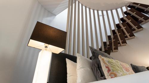 a lamp next to a bed with pillows at Hotel Sardinero Madrid in Madrid