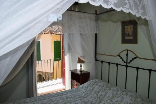 a bedroom with a canopy bed and a balcony at Oikia Ahanasia in Karlovasi