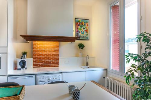 a kitchen with a sink and a stove at #3 Toulon CENTRE, BALCON, LUMINEUX, STATIONNEMENT FACILE, TOUT CONFORT in Toulon
