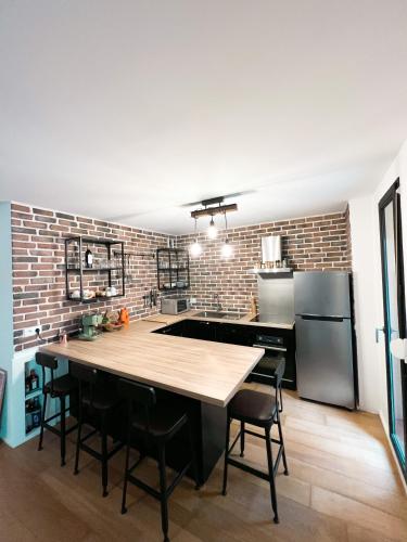 een keuken met een houten tafel en een bakstenen muur bij Appartement Bayonne in Bayonne
