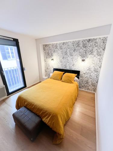 een slaapkamer met een geel bed en een raam bij Appartement Bayonne in Bayonne