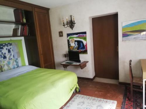 a bedroom with a bed and a desk with a laptop at DUE QUERCE in Conscio